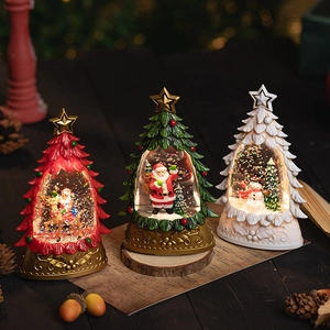 Light-up Christmas tree snow globe set with Santa and snowman on a wooden surface