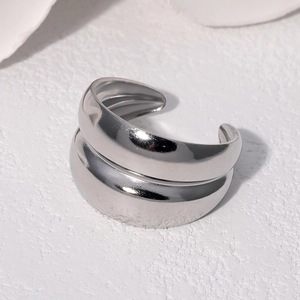 Detail of silver double-layered open ring with minimalist metallic finish on stone surface