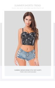 Dettaglio degli shorts in denim a vita bassa con top all'americana in ecopelle e borchie