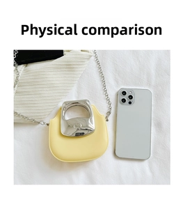 Detailed top view of a mini yellow saddle bag with an oversized silver metal handle