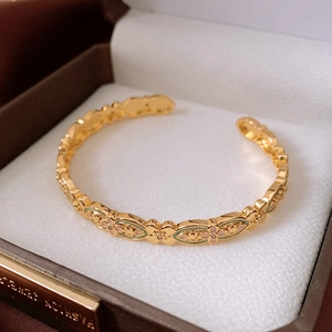 Detail of 18k gold plated open bangle with filigree enamel flowers and small diamonds