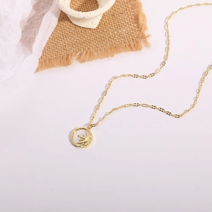Detail shot of a 14K gold plated sun and moon necklace on a rustic linen background