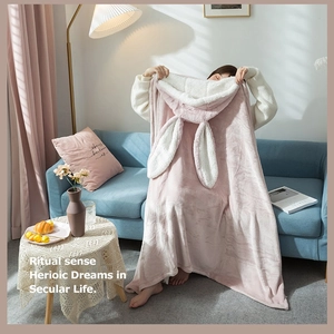 Pink rabbit-ear hooded blanket with sherpa fleece lining shown in a cozy home setting