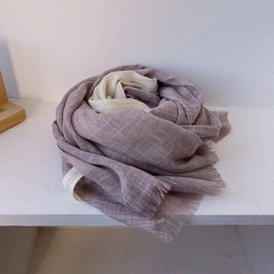 Detail of purple and beige cotton linen scarf featuring soft tassels and woven texture