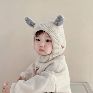 Détail du bonnet en tricot beige pour bébé avec cache-cou et oreilles grises