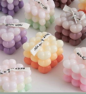 Macro shot of gradient cube bubble candles with elegant ribbons for home decor