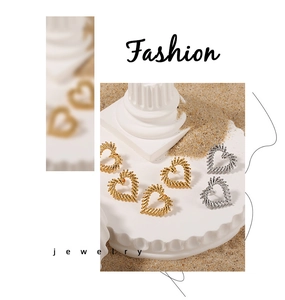 Detailed view of hollow heart earrings with spiral texture in gold and silver finish