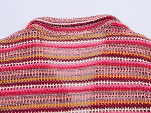 Close-up of multicolor hollow crochet polo shirt with detailed wave knit pattern