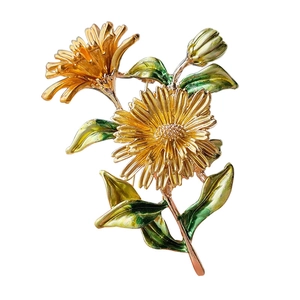 Elegant gold daisy brooch with green enamel leaves and vintage floral metal design