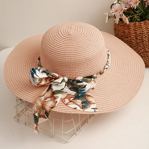 Chapeau de paille rose à large bord avec ruban floral et détails de perles élégants