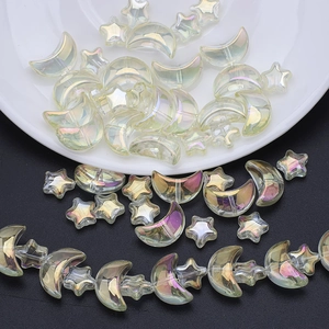 Detailed view of iridescent moon and star glass beads set on a ceramic dish for DIY jewelry