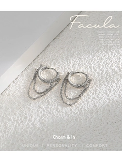 Detail of silver huggie earrings with cubic zirconia and multi-layered chain tassels