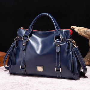 Bolso de mano retro de cuero suave azul marino con detalles dorados y borlas