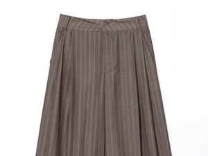 Détail du pantalon large à taille haute plissée en gris avec de fines rayures verticales