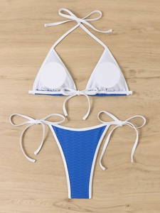 Detailed flat lay of triangle bikini set with blue wave texture and white mesh lining