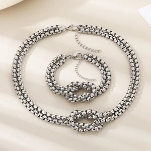 Detail of silver dual-layer braided chains featuring a knotted design with lobster clasps