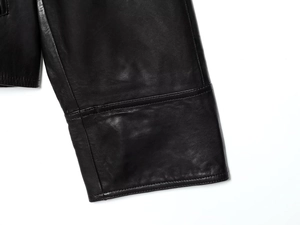Gros plan des coutures précises et de la texture du cuir sur le poignet de la veste noire