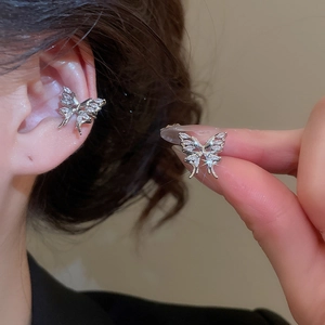 Close-up of elegant silver butterfly ear cuff with sparkling zircon tassel detail