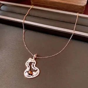 Vintage rose gold gourd necklace with tiger eye stone and pearls on display