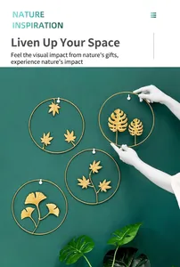 Detail of four golden metal leaf wall art pieces showing intricate ginkgo and maple designs