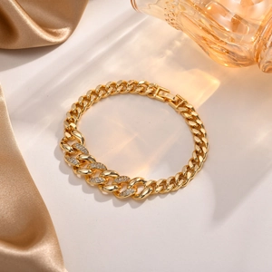 Detailansicht eines goldenen Gliederkettenarmbands mit Zirkonia auf cremefarbener Seide