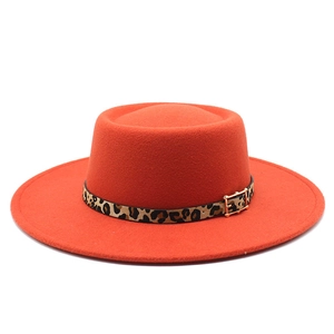 Gros plan du chapeau en feutre orange avec ruban léopard et boucle dorée élégante