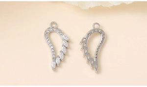 Detail view of silver wing charms with marquise-cut zircons and hollow back design