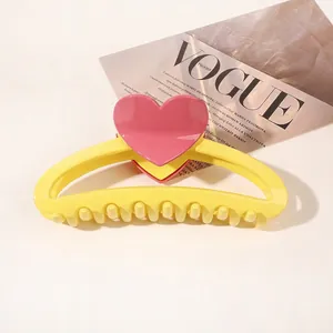 Detail of yellow heart hair claw clip with pink accents on a fashion magazine