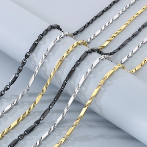 Trois colliers minimalistes en acier titane noir, or et argent sur un support élégant