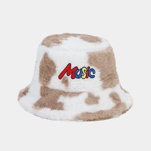 Detailed view of MUSIC embroidery and soft cow print plush texture on fisherman hat