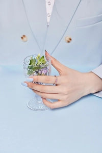 Detailed view of a silver ring featuring multi-colored gemstones worn on a finger