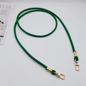 Dettaglio della tracolla in pelle PU verde con ganci girevoli dorati e rifiniture