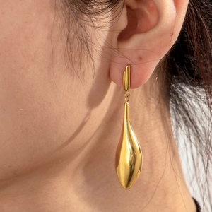 Elegant gold drop earrings with polished finish on model in a bohemian goddess style