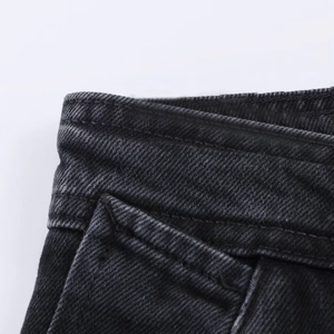 Détails de la couture à la taille et des poches sur un jean en denim noir délavé vintage
