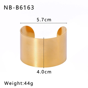 Detalle del brazalete de 4,0 cm en acero inoxidable chapado en oro 18k con grabado de hoja