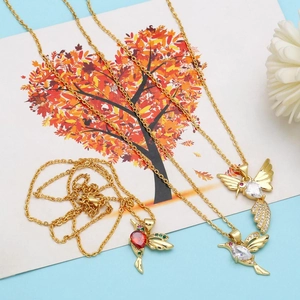 Detailed view of hummingbird pendant necklaces with red and white zircons in gold finish