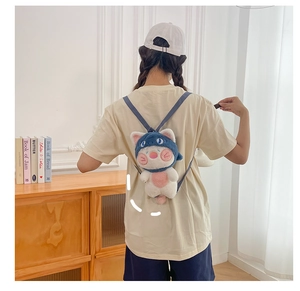 Detail view of a cute shark cat plush backpack worn on back in a cozy home setting