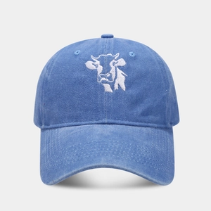 Close-up of cow embroidery on washed navy blue vintage cotton baseball cap with curved brim