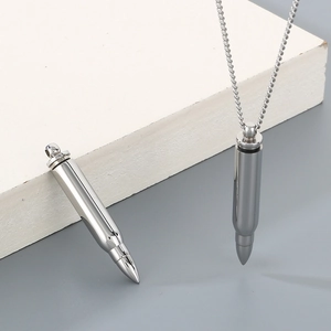 Macro detail of polished stainless steel bullet pendant necklace with chain attachment