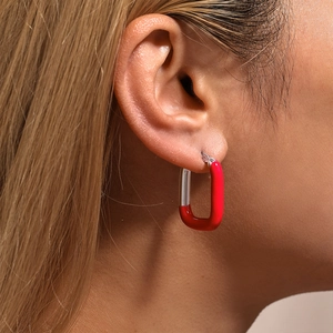 Boucles d'oreilles en acier inoxydable doré et émail rouge portées par un mannequin