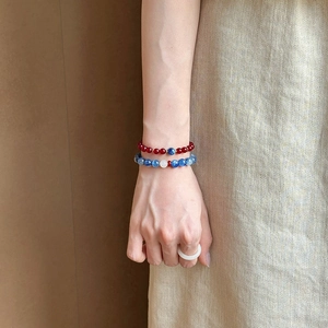 Detail of beaded agarwood and agate bracelet set with blue crystal worn on wrist