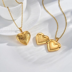 Detailed macro view of an openable gold heart locket necklace with vintage floral carvings