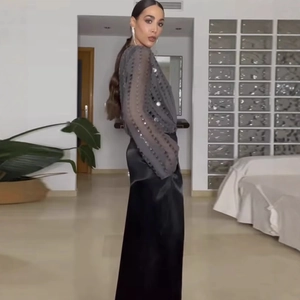 Chic women's V-neck sequined long sleeve bodysuit paired with a black satin maxi skirt