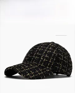 Détail rapproché d'une casquette de baseball en tweed noir et doré à texture tissée