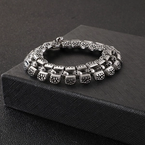 Punk style stainless steel skull bracelet for men displayed on a black jewelry box