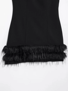 Gros plan détaillé de l'ourlet de la robe noire avec garniture élégante en plumes