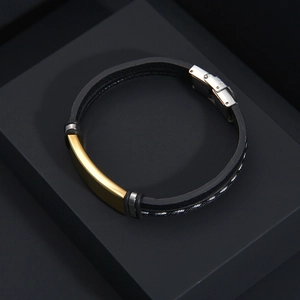 Close-up of men's black woven PU leather bracelet with a gold metal plaque