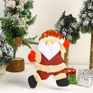 Detail of Christmas Santa plush ornament with red green plaid hat and festive scene