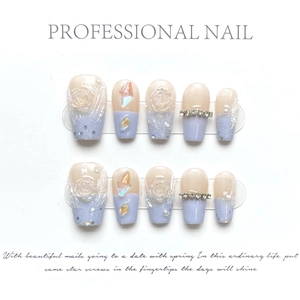 Close-up of handmade press-on nails with 3D roses and rhinestones on cream gradient