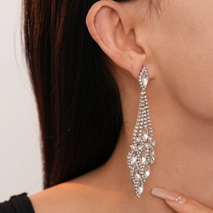 Eleganti orecchini a nappa in argento con strass geometrici a goccia indossati dal modello